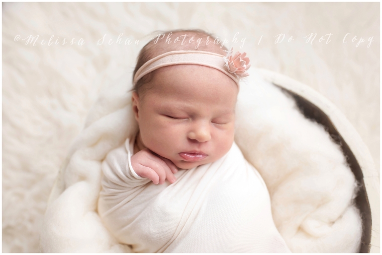 Swaddled sleeping newborn with headband 