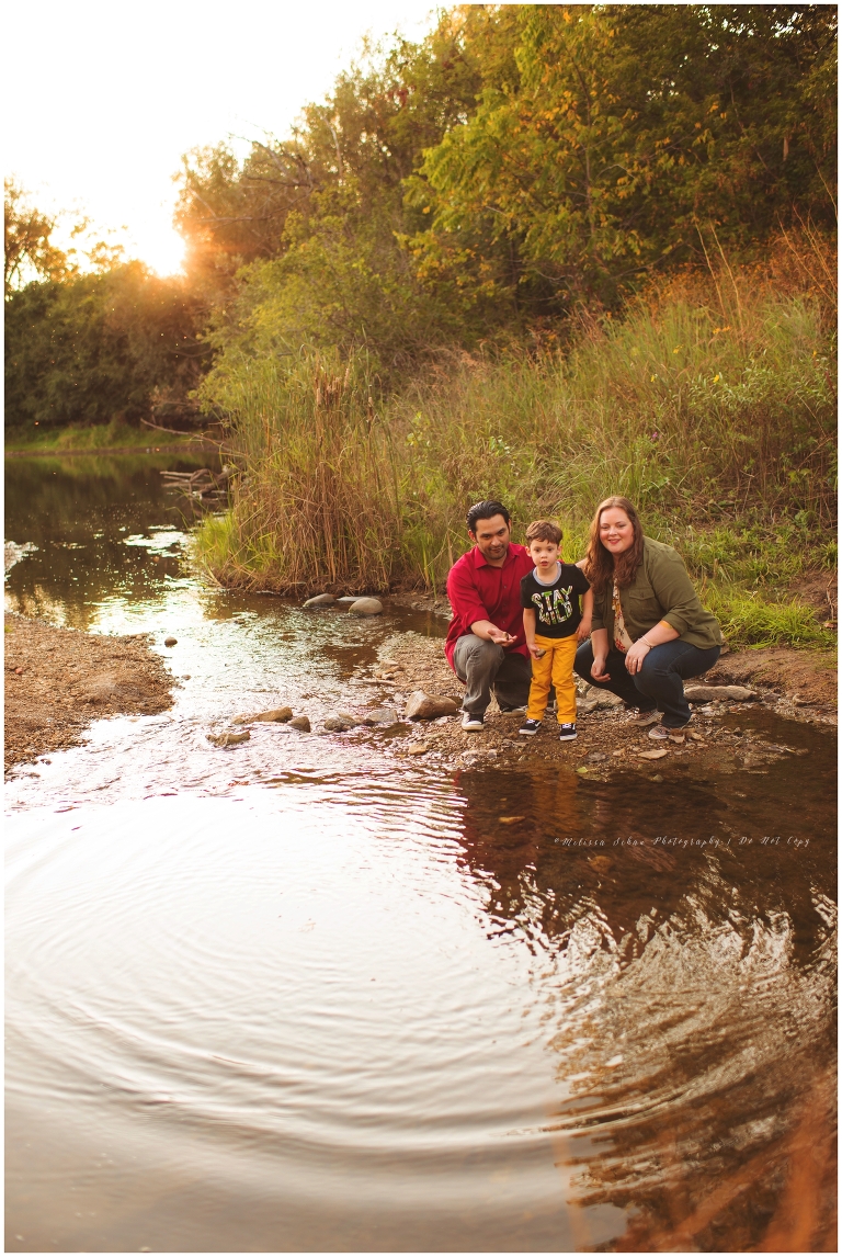 family throwing rocks in creek during outdoor photography session