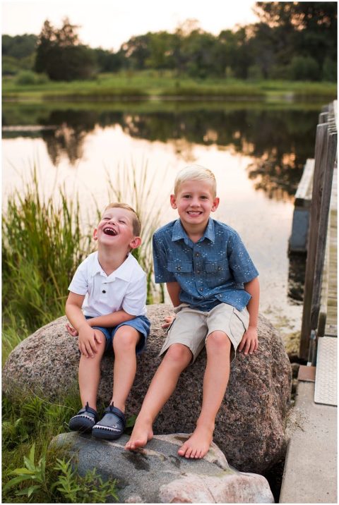 Two young boys sitting on large rock